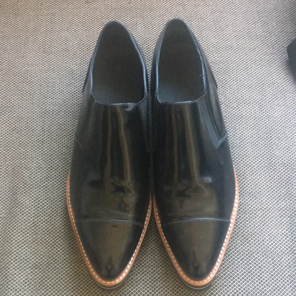 Vince Pair of black vinyl sneakers.